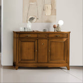 Credenza classica in legno di ciliegio con due ante laterali e un vano centrale portabottiglie, elegantemente nascosto. Completano il mobile tre cassetti superiori, di cui uno centrale segreto, perfettamente integrato nel design. Collezione Arte d’Este Piombini.