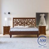 Letto matrimoniale classico in legno di ciliegio con raffinata testata traforata in stile barocco, collezione Arte di Piombini. Arredo elegante Made in Italy, celebrativo del centenario 1925–2025, perfetto per ambienti ricercati e senza tempo.