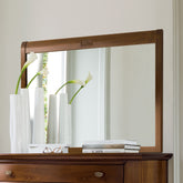 Specchiera classica Arte 8875J in vero legno di ciliegio, collocata sopra un comò coordinato e illuminata dalla luce naturale che esalta le venature del legno, l'armonia delle proporzioni e l'eleganza dell'ambiente domestico.