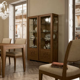Vetrina moderna in legno di noce con doppia anta in vetro e decoro Comete, collezione Modigliani di Piombini. Mobile espositore elegante con ripiani in vetro, ideale per mostrare porcellane e oggetti preziosi in ambienti raffinati dal gusto classico contemporaneo.