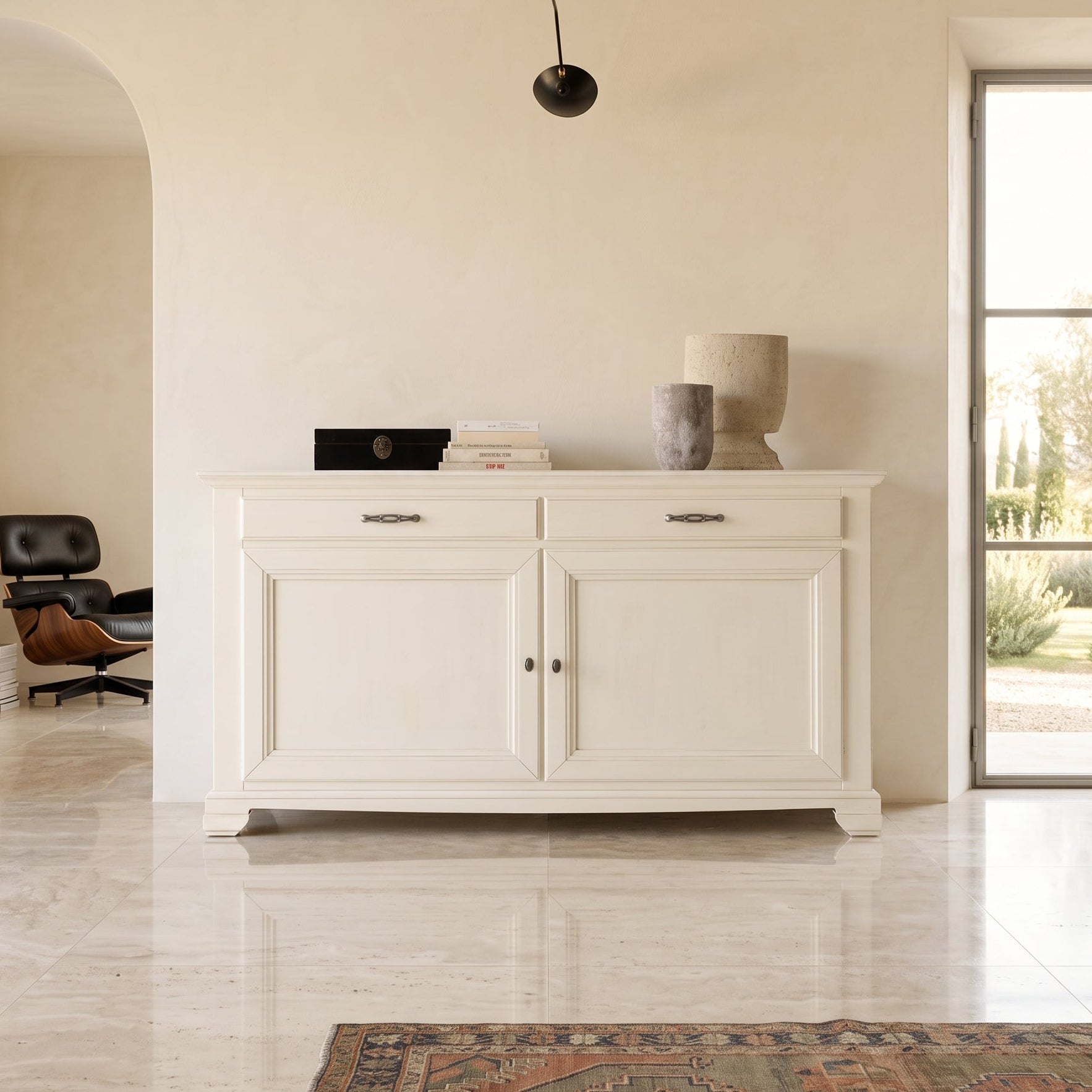 Credenza classica bianca laccata con due porte e due cassetti, ambientata in un interno luminoso ed essenziale.