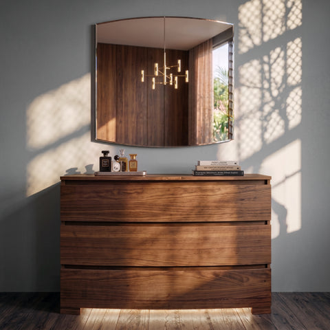 Comò liscio contemporaneo 8273 in vero legno con specchiera coordinata Modigliani 8275, illuminati dalla luce naturale che valorizza le venature del legno, l'equilibrio delle proporzioni e l'eleganza dell'ambiente contemporaneo.
