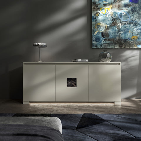 Credenza Modigliani Piombini a 3 ante in finitura Onice con inserto in marmo nero Port Saint Lauren; ambientazione in stile Soft Modern con lampada Flos Bon Jour, vaso Venini Monofiore Balloton fumè, tappeto geometrico blu e divano moderno grigio.