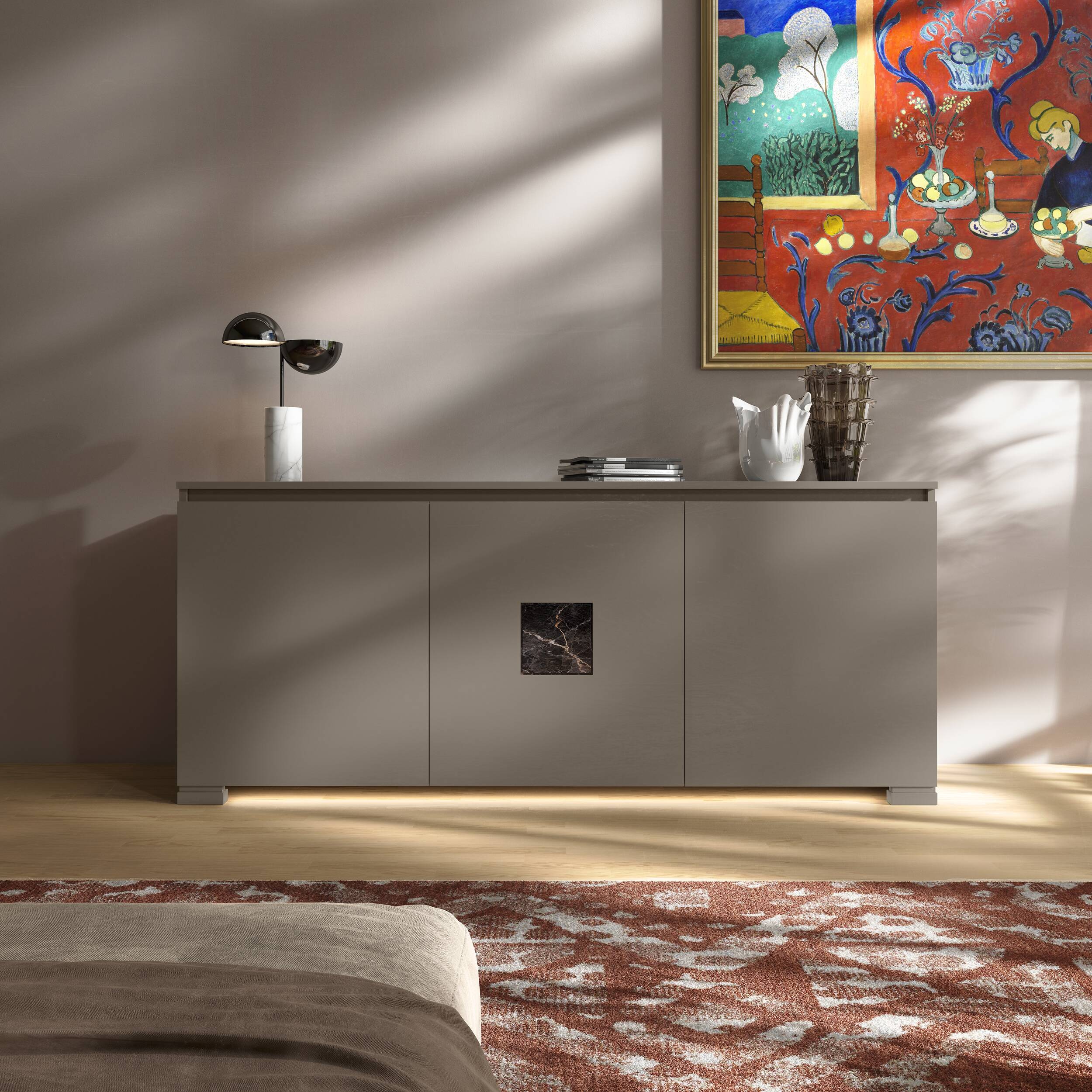 Credenza Modigliani Piombini a 3 ante in finitura Tortora con inserto in marmo nero Port Saint Lauren; ambientazione in stile Soft Luxury con lampada Penta Elisabeth, vaso Venini Fazzoletto, vaso Venini Ritaglio, tappeto contemporaneo rosso e divano moderno beige.