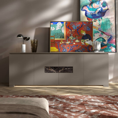 Credenza Modigliani Piombini a 4 ante in finitura Tortora Laccato con inserto in marmo nero Port Saint Lauren; ambientazione in stile Soft Luxury con lampada Penta Elisabeth, vaso Venini Fazzoletto, vaso Venini Ritaglio, tappeto moderno rosso e divano moderno sabbia.