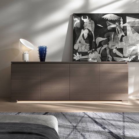 La credenza Modigliani 4 Porte nella finitura Noce Cenere, ambientata nel Mood Minimalismo Nordico.
Eleganza materica, ante lisce, lampada Flos Taccia, vaso Venini Ritagli e luce LED per uno stile caldo e personale.