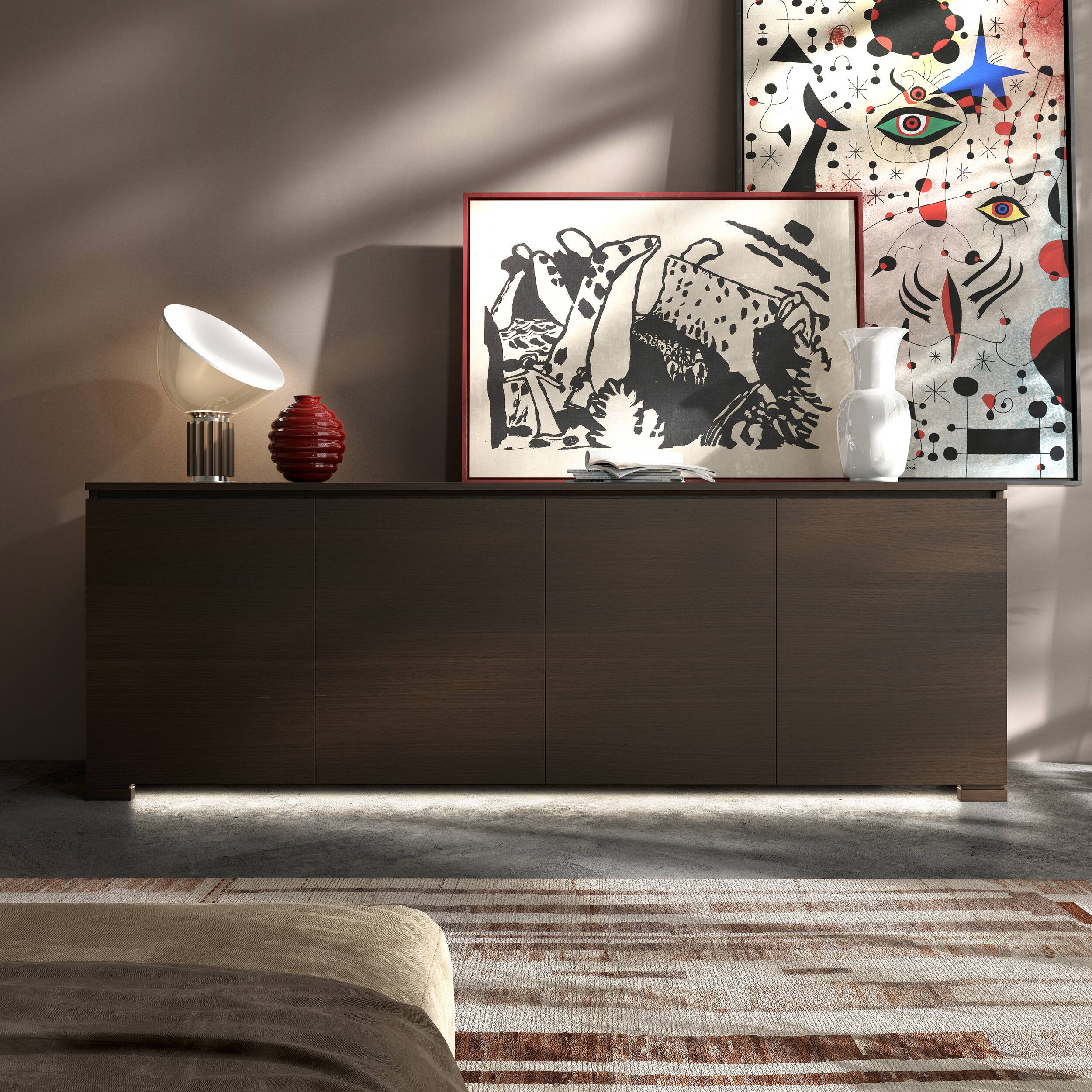La credenza Modigliani 3 Porte nella finitura Noce Moka, ambientata nel Mood Etnico Moderno.
Eleganza materica, ante liscie, lampada Flos Taccia, vaso Venini Opalino, vaso Venini Deco e luce LED per uno stile caldo e personale.
