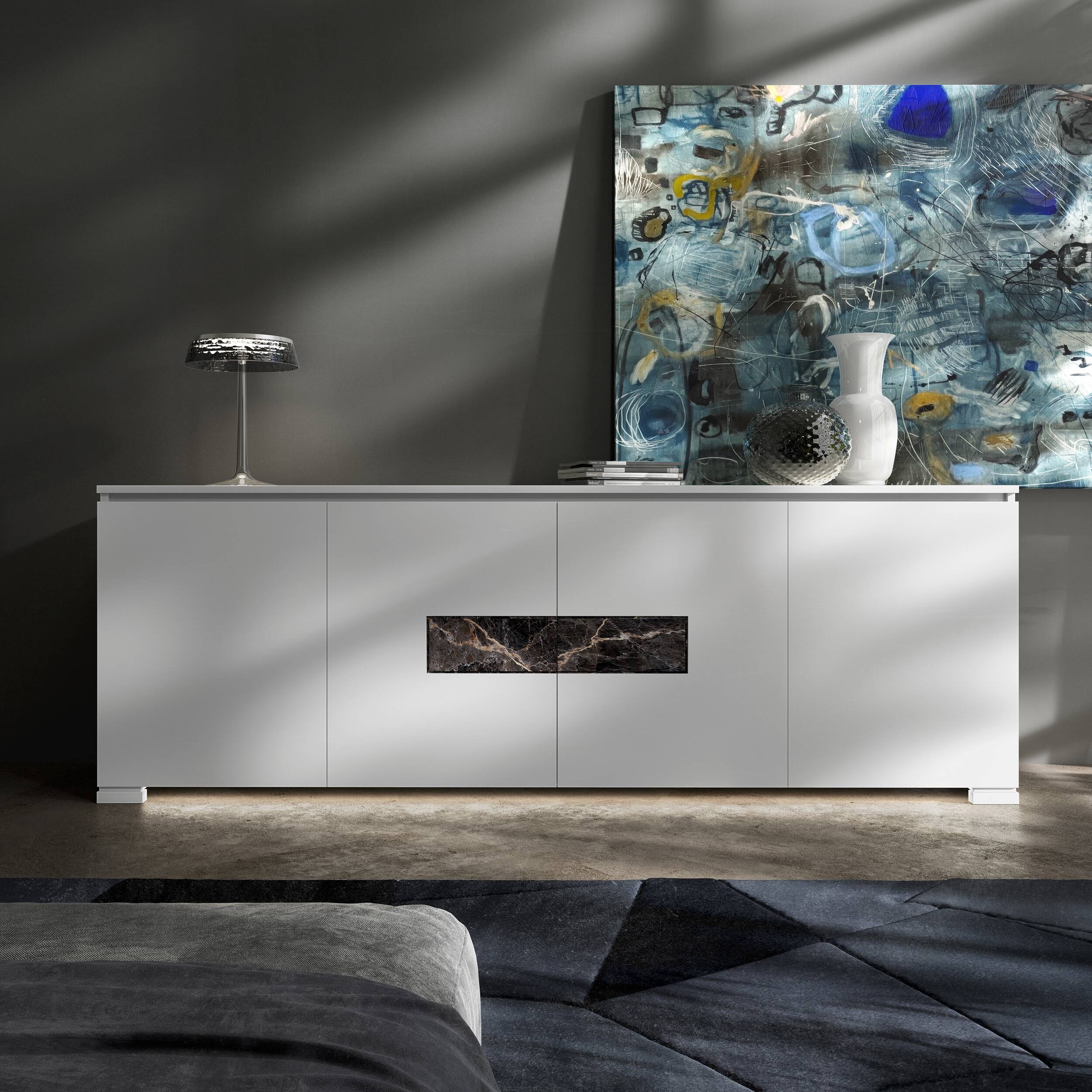 Credenza Modigliani Piombini a 4 ante in finitura Bianco Laccato con inserto in marmo nero Port Saint Lauren; ambientazione in stile Soft Modern con lampada Flos Bon Jour, vaso Venini Monofiore Balloton fumè, vaso Venini Opalino, tappeto geometrico blu e divano moderno grigio.