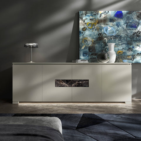 Credenza Modigliani Piombini a 4 ante in finitura Onice Laccato con inserto in marmo nero Port Saint Lauren; ambientazione in stile Soft Modern con lampada Flos Bon Jour, vaso Venini Monofiore Balloton fumè, vaso Venini Opalino, tappeto geometrico blu e divano moderno grigio.