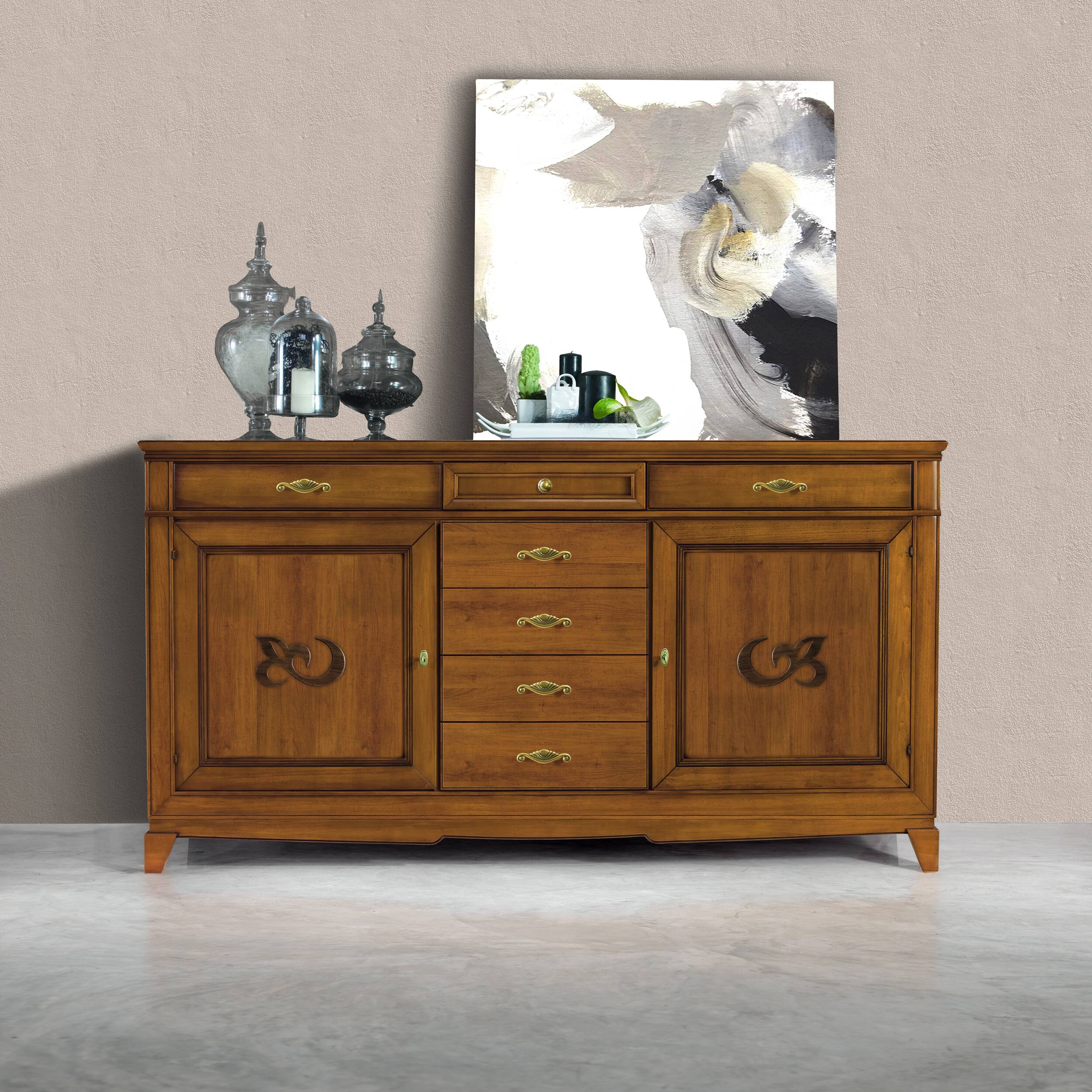 Credenza modello P3010 della collezione Arte d'Este di Piombini, in legno finitura GRN14 Bassano chiaro anticato. Design classico italiano con due ante laterali, due cassetti sopra le ante e cinque cassetti centrali, esposta contro una parete neutra con decoro contemporaneo e vasi in vetro.