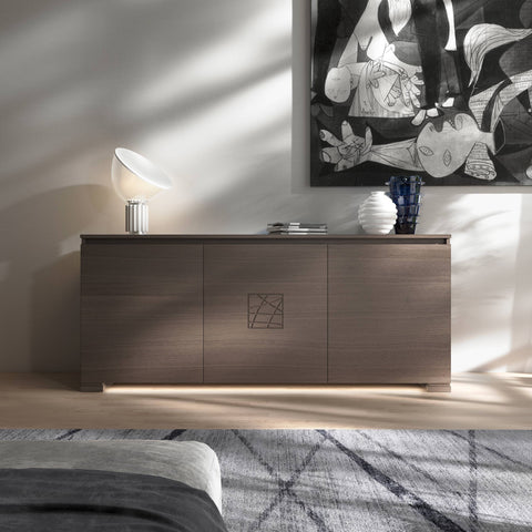 Credenza Modigliani Piombini a 3 ante in finitura Cenere con decoro Comete; ambientazione in stile Minimalismo Nordico con lampada Flos Taccia, vaso Venini Deco bianco e vaso Venini Ritaglio blu, tappeto geometrico e divano moderno grigio.