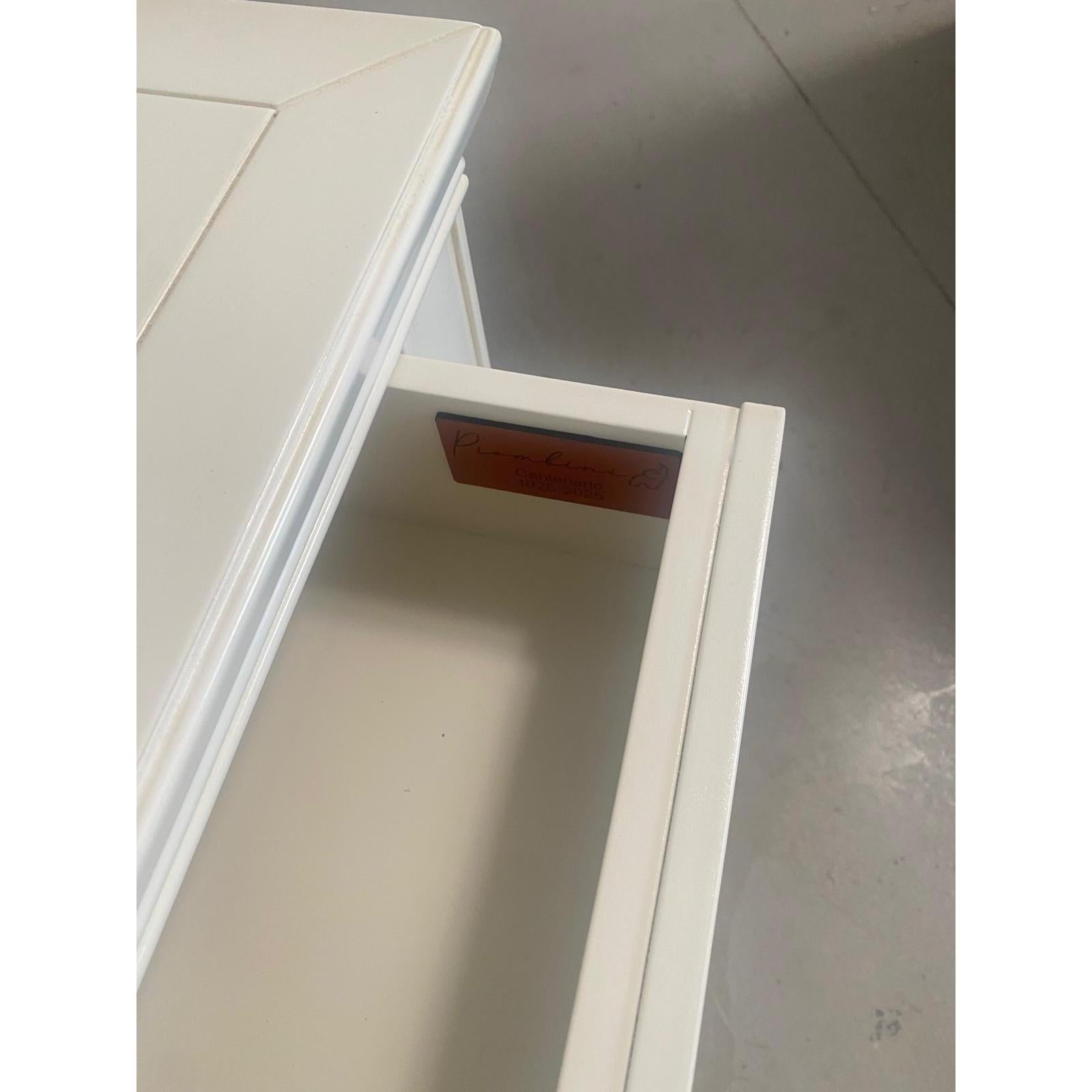 Dettaglio del cassetto interno del comodino codice P3100/L/26 con firma Piombini applicata. La laccatura chiara rifinita a mano si estende anche alle superfici interne, confermando la qualità artigianale dell’intero mobile. La firma Piombini, elegante e discreta, testimonia l’autenticità del prodotto e il valore della manifattura. Un elemento che unisce estetica, funzionalità e orgoglio della tradizione italiana.