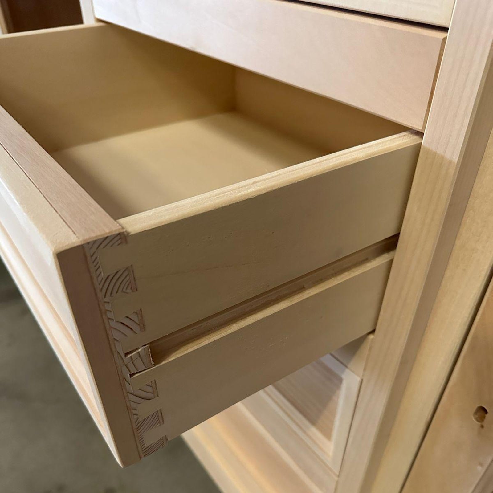 Dettaglio incastro a coda di rondine del cassetto in legno allo stato grezzo della credenza Tiziano RH608, lavorazione artigianale che garantisce resistenza e precisione