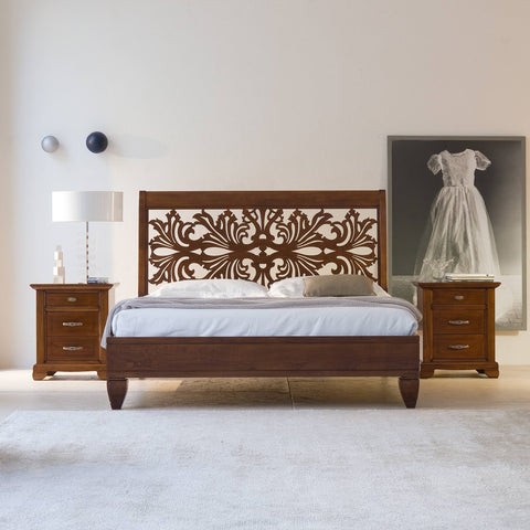 Letto matrimoniale in stile classico realizzato in pregiato legno di ciliegio con testata traforata decorativa, collezione Arte di Piombini. Design italiano raffinato ideale per camere da letto eleganti e tradizionali.