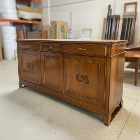 Credenza classica D'Este P3003 in legno vista di tre quarti in falegnameria, con tre porte, tre cassetti, cornici lavorate e decori in Noce Canaletto.