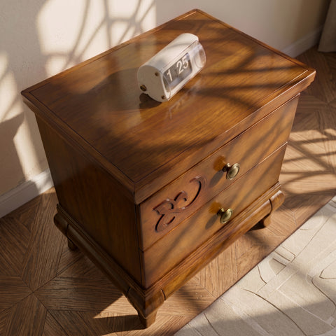 Dettaglio dall’alto del comodino D’Angiò: piano in legno con venature visibili, due cassetti con pomelli tondi e un decoro curvo sul frontale superiore.