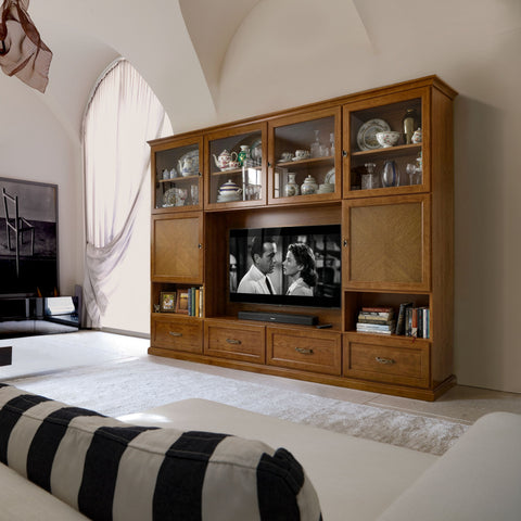 Parete soggiorno classica Piombini RH6240 della collezione Tiziano, ambientata in un elegante soggiorno contemporaneo. Mobile in legno con quattro vetrine superiori, ante con lavorazione in rovere a spina, ampio vano TV centrale, quattro cassetti e vani contenitore, progettato per arredare con eleganza ambienti classici e moderni.