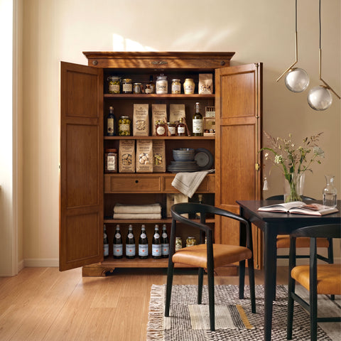 Armadio Dispensa Tiziano RH110 aperto, ambientato in una luminosa sala da pranzo, con interno organizzato da ripiani regolabili e cassettiera, ideale per custodire stoviglie, alimenti, biancheria e oggetti della casa con l'eleganza del mobile artigianale Piombini.