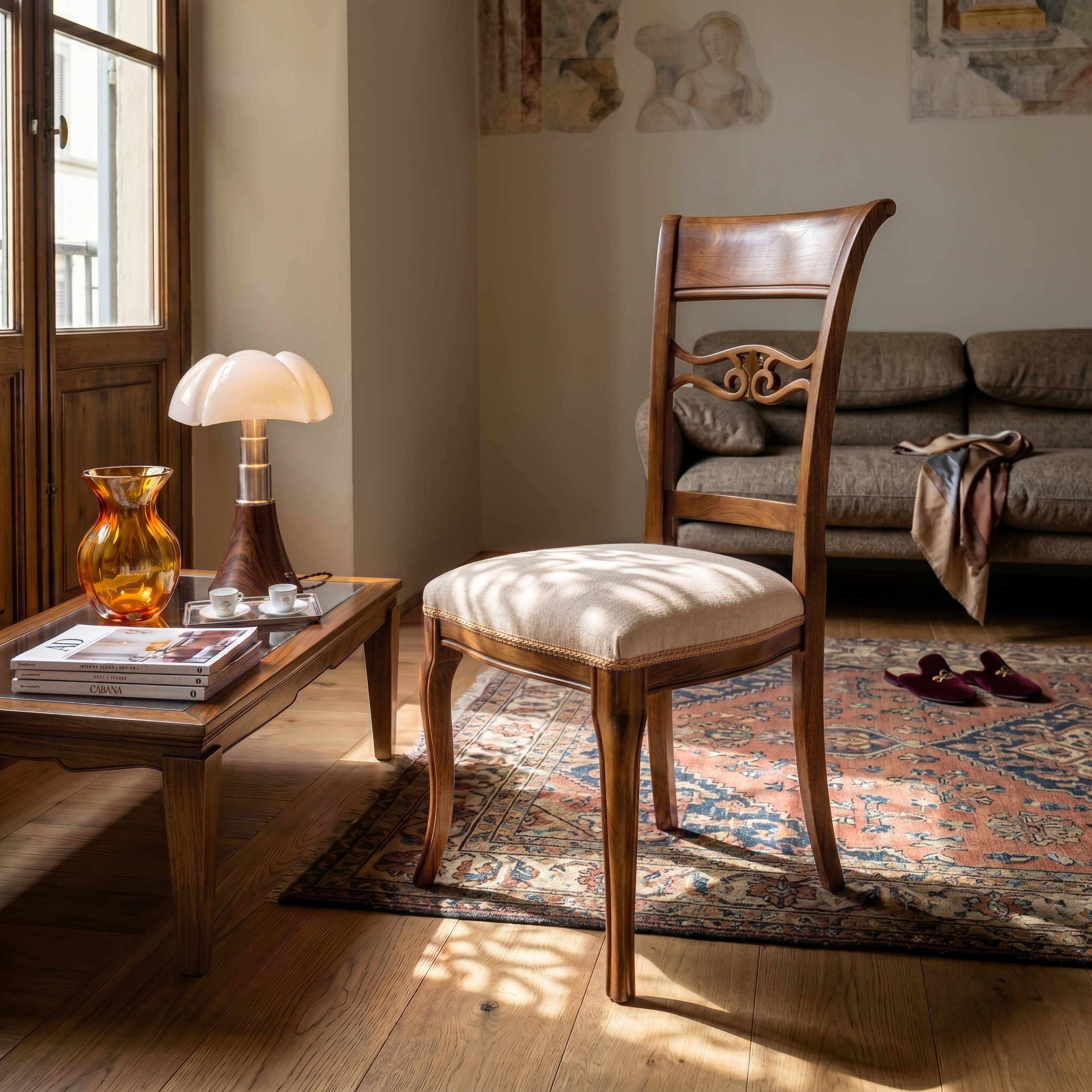 Sedia classica Vittoria in legno massello con seduta imbottita rivestita in tessuto MX Andromeda T1 Ecrù, inserita in soggiorno elegante con tavolino in legno, tappeto decorato e luce naturale proveniente dalla finestra