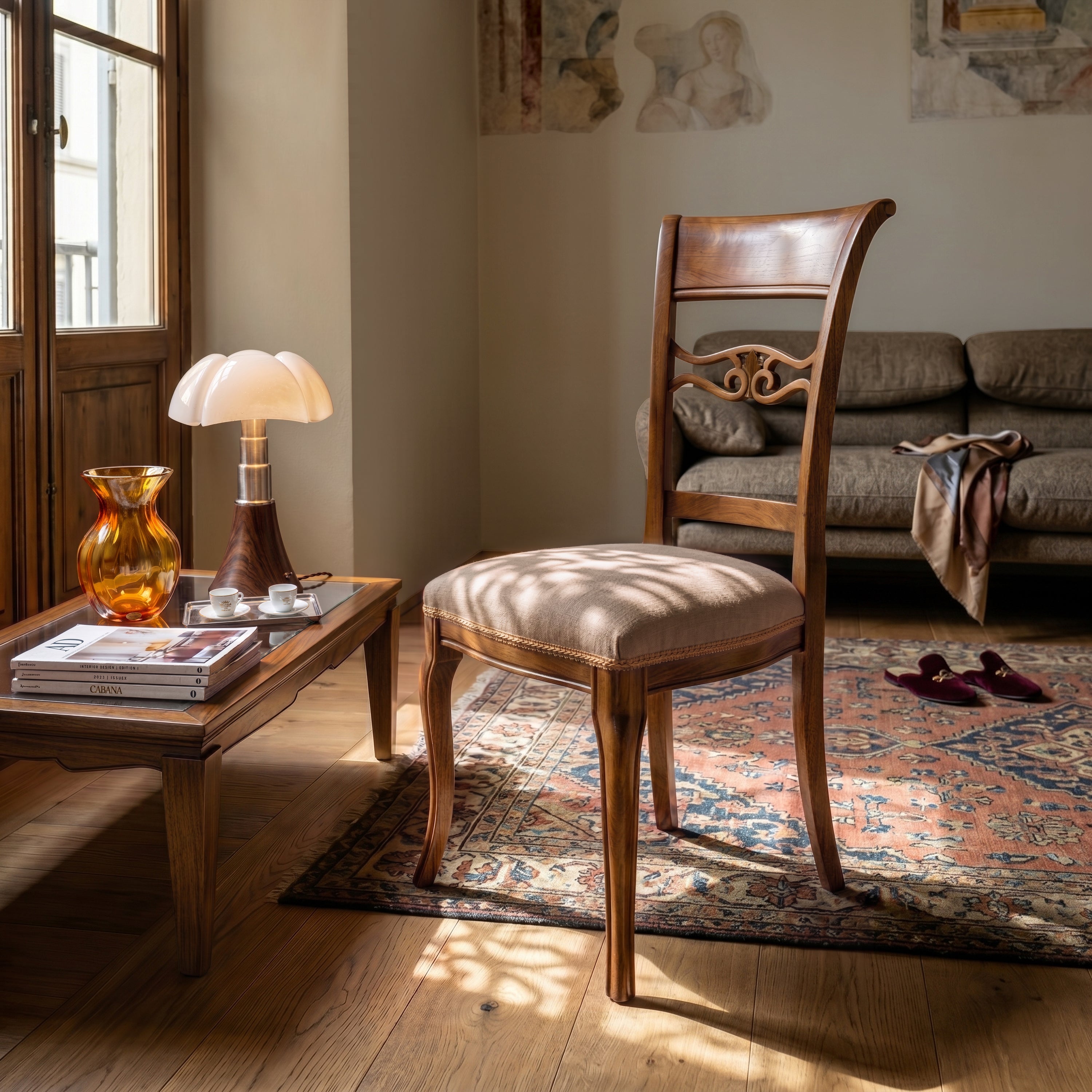 Sedia classica Vittoria in legno massello con seduta imbottita rivestita in tessuto MX Andromeda T2 Nocciola, posizionata in soggiorno elegante con tavolino in legno, tappeto decorato e luce naturale proveniente dalla finestra