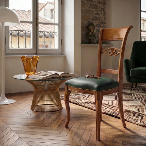 Sedia classica Vittoria in legno massello con seduta imbottita rivestita in vera pelle Siviglia Top Bosco, fotografata in un elegante soggiorno luminoso con dettagli di design e atmosfera raffinata