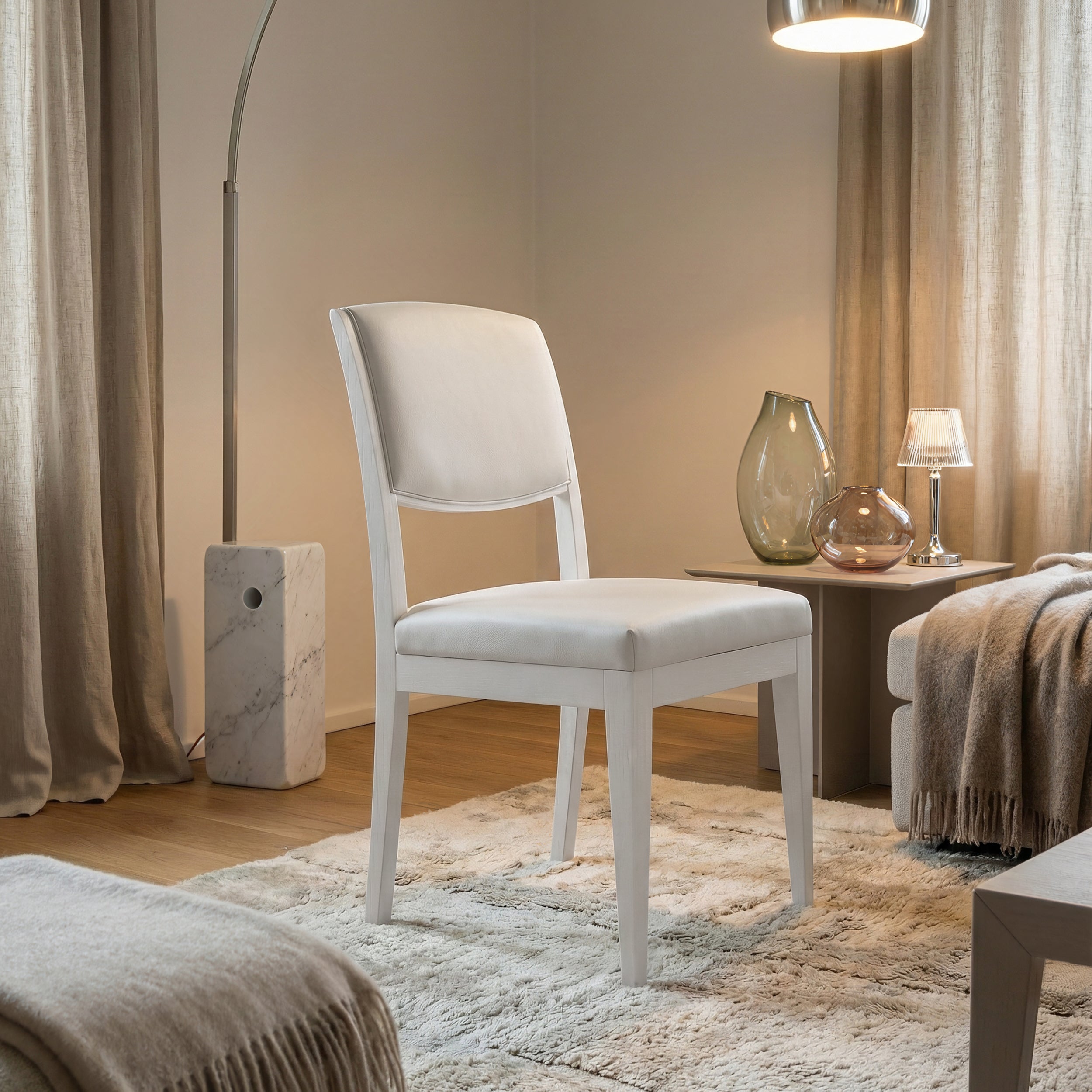 Sedia da pranzo moderna con struttura in legno di noce canaletto Laccato Bianco e rivestimento in pelle Bianca , ambientata in un salotto elegante e luminoso.