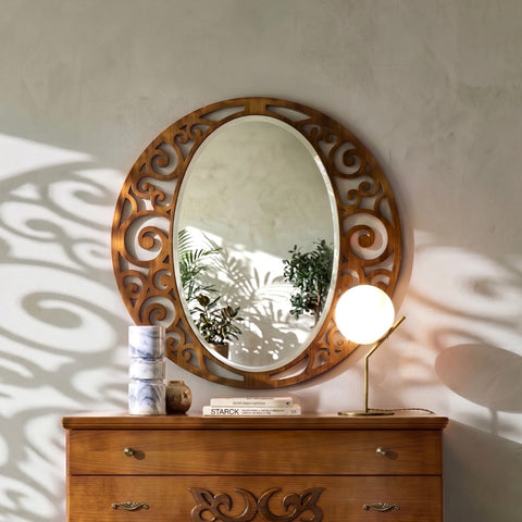 Klassischer ovaler durchbrochener Spiegel P4105 aus echtem Holz, über einer passenden Kommode platziert und von natürlichem Licht beleuchtet, das feine Schattenspiele an der Wand erzeugt und die filigrane Verarbeitung und Eleganz betont.