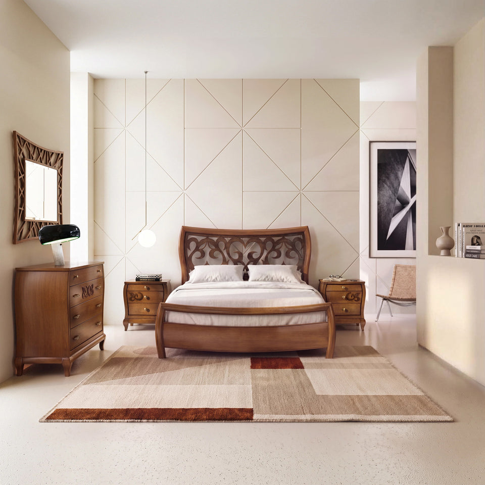 Dormitorio matrimonial clásico Smart Visconti en cerezo con cama curvada y piecero, cómoda, mesillas y espejo. Espacio luminoso y cálido: la madera aporta presencia, la luz acaricia las formas y transmite equilibrio, intimidad y calma.