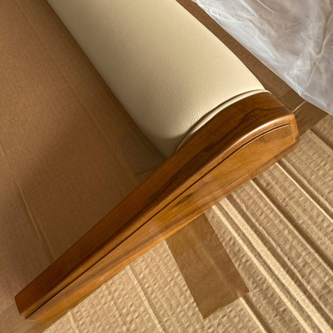 alt
Detail of the walnut wood frame of the Modigliani bed with beige leather upholstery on the footboard. Handcrafted workmanship highlighted by natural light. 1925–2025 centenary logo at bottom right.